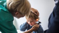 KNO-arts kijkt bij kindje in het oor
