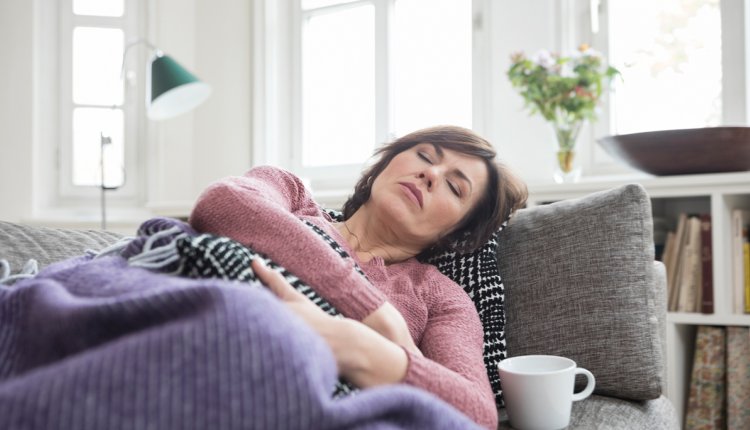 Vrouw met buikpijn op de bank