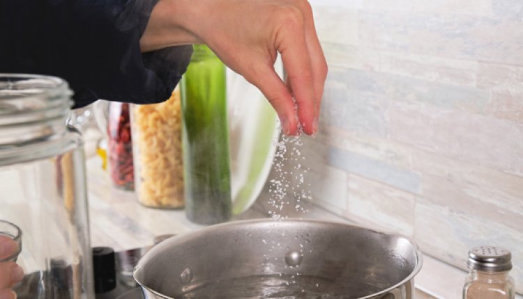 Vrouw kookt pasta met zout