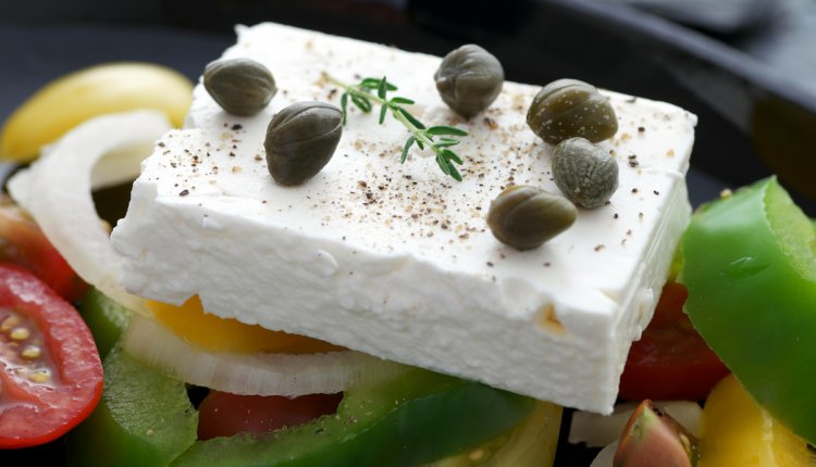 Stuk feta op een Griekse salade met olijven