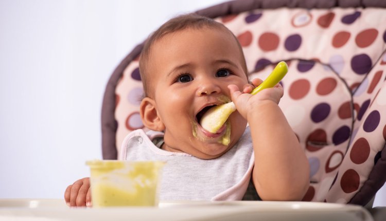 Baby eet zijn eerste hapjes