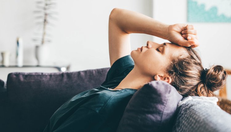 Vrouw ligt gestresst op de bank