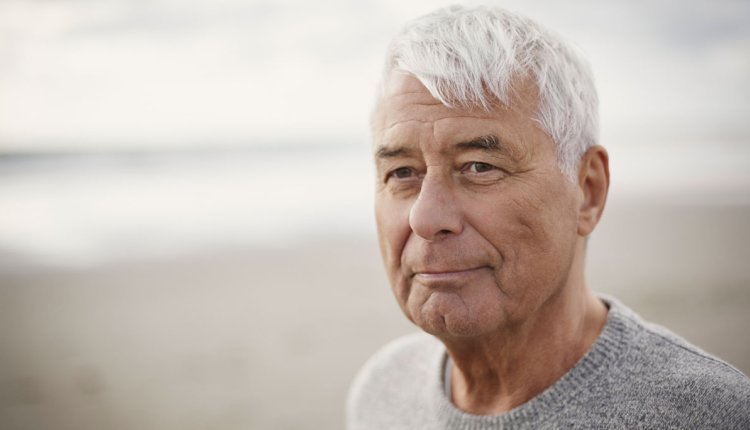 Man op het strand in zijn trui op een mooie herfstdag