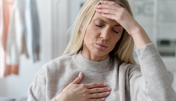 Vrouw met stress grijpt naar haar hoofd en hart 