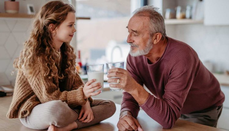 opa en kleindochter drinken melk aan aanrecht