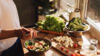 Vrouw in de keuken maakt gezonde maaltijd