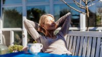 Vrouw geniet van de eerste zonnestralen in de zon