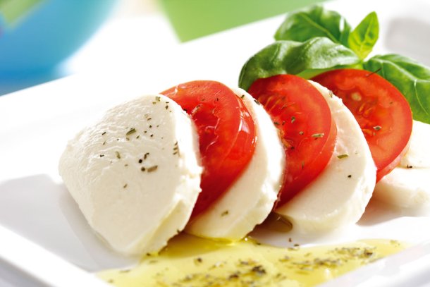 Caprese op een bord, oftewel mozzarella, tomaat en basilicum met olijfolie