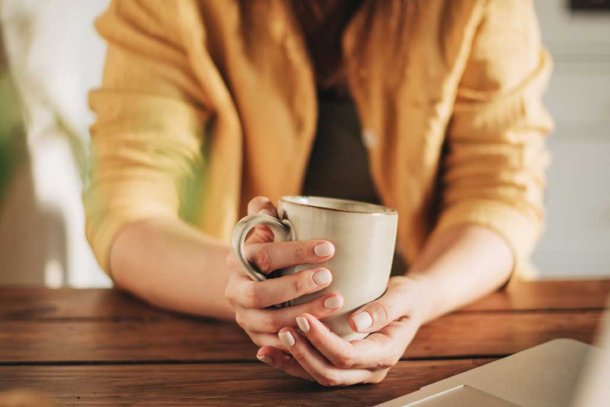 vrouw drinkt koffie achter computer