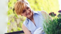 Vrouw op balkon aan het tuinieren