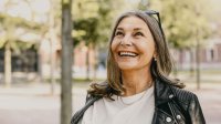 Vrolijke vrouw met zonnebril in haar haar