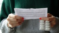 Vrouw leest bijsluiter van medicatie