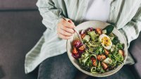 Vrouw eet gezonde maaltijd volgens het AHEI-dieet