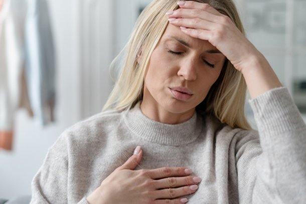 Vrouw met stress grijpt naar haar hoofd en hart 