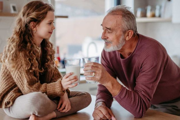 opa en kleindochter drinken melk aan aanrecht